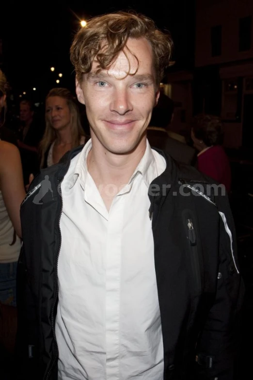 a man wearing a white shirt and jacket at a party