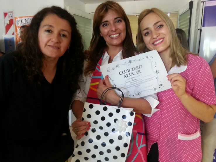 three woman with shopping bags posing for a picture