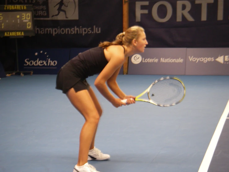 a woman bending over to hold a tennis racket