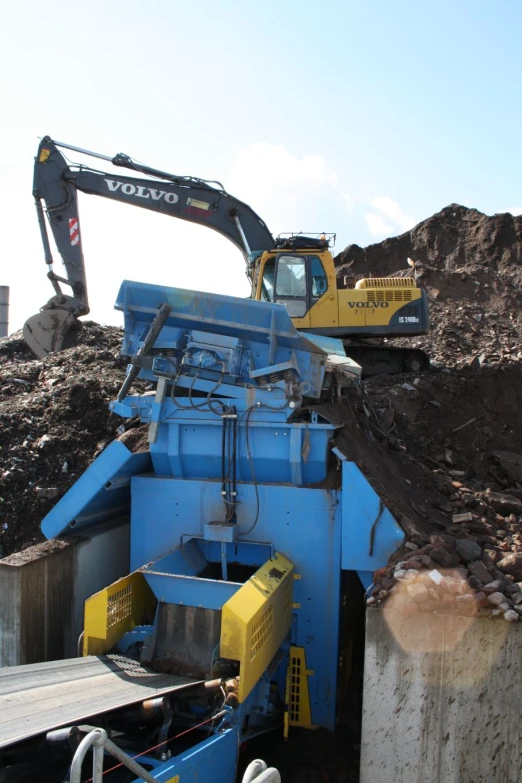 an excavator removes dirt from a pile at a construction site