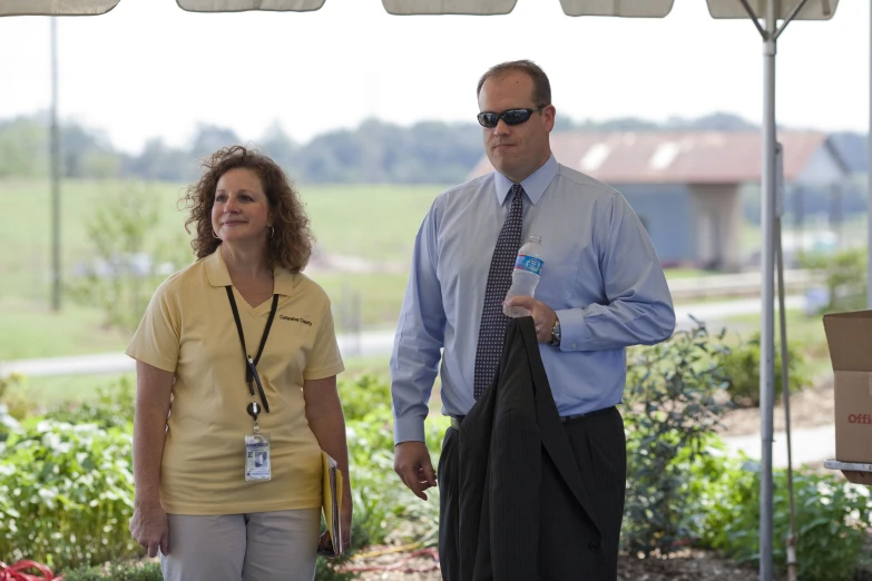 a woman talking with a man under a white tent