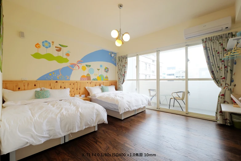 the bedroom has two double beds, a balcony, and an image of the child's play area