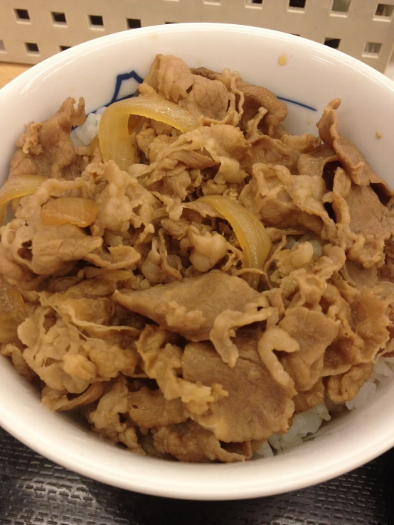 a bowl filled with some food next to a pile of cut meat