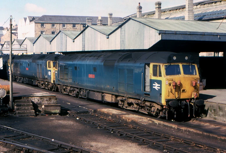 a blue and yellow train coming down the track