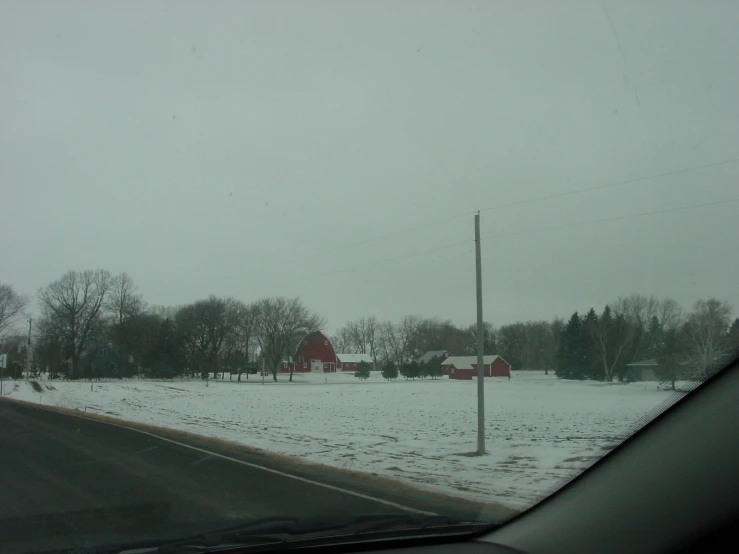 the view of snow covered ground from a windshield