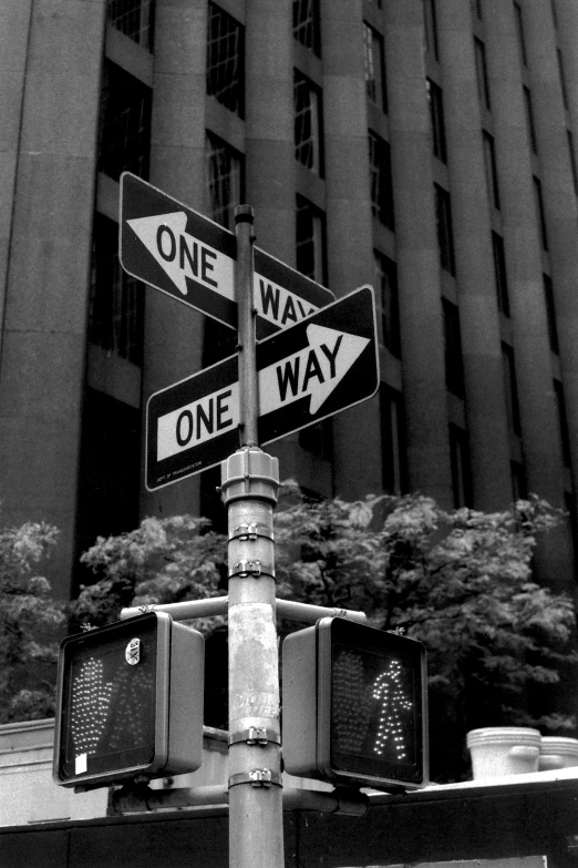 two street signs on one pole that says one way