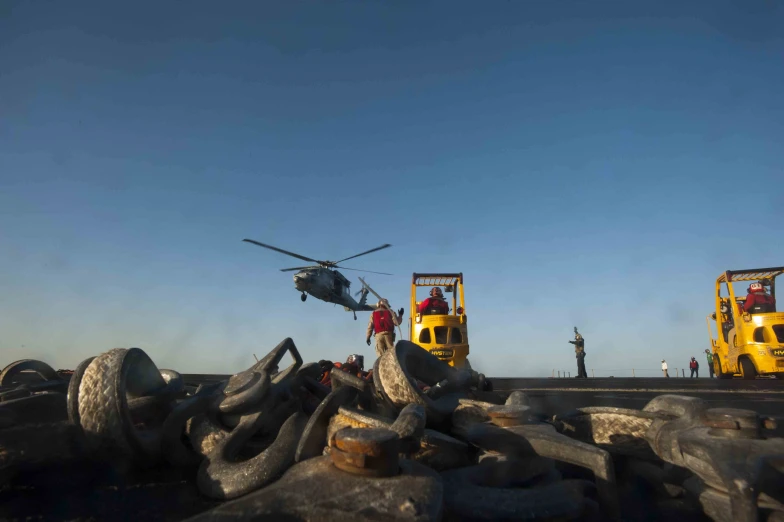 a helicopter that is flying over some dead tree trunks