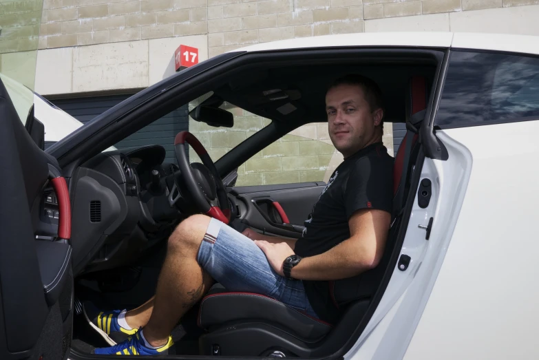 a man driving a vehicle with its seat up and the interior door open