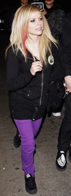 a person with very thin hair in a black jacket and purple pants