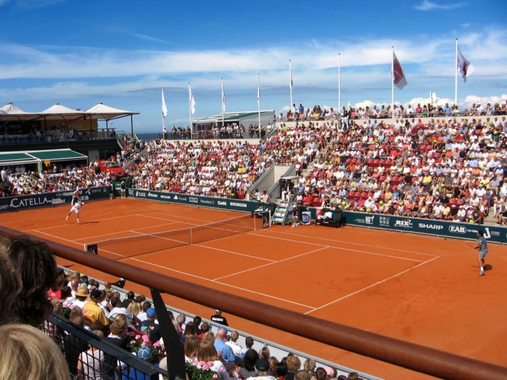 the tennis match is being played in front of a large crowd