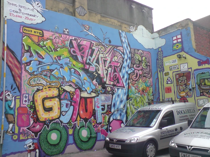 a van parked next to a wall covered in graffiti
