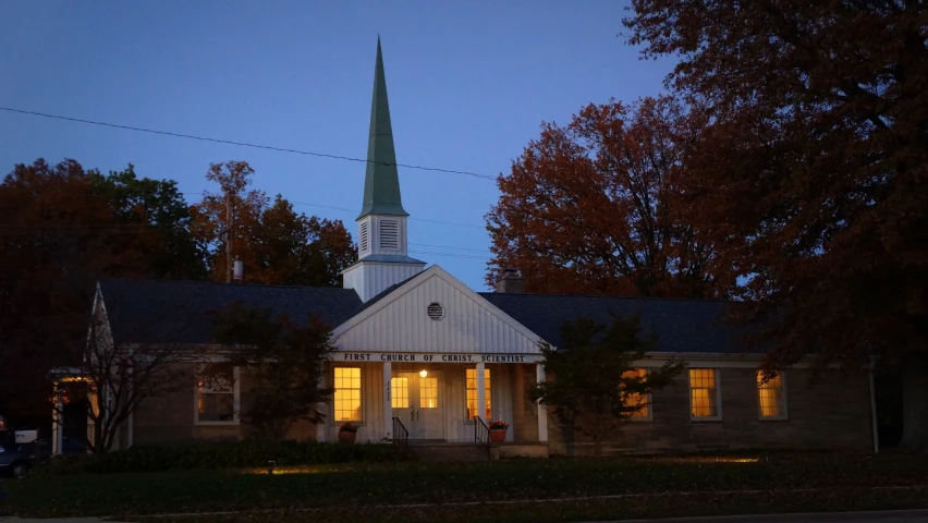 a church at dusk with the tower in the background