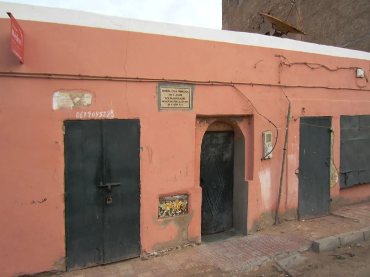 a pink building with black doors and windows