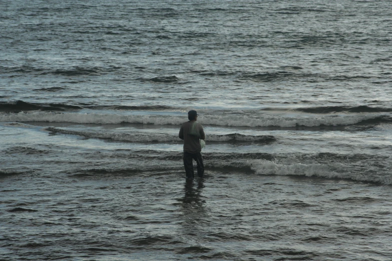 person standing in water in large body of ocean