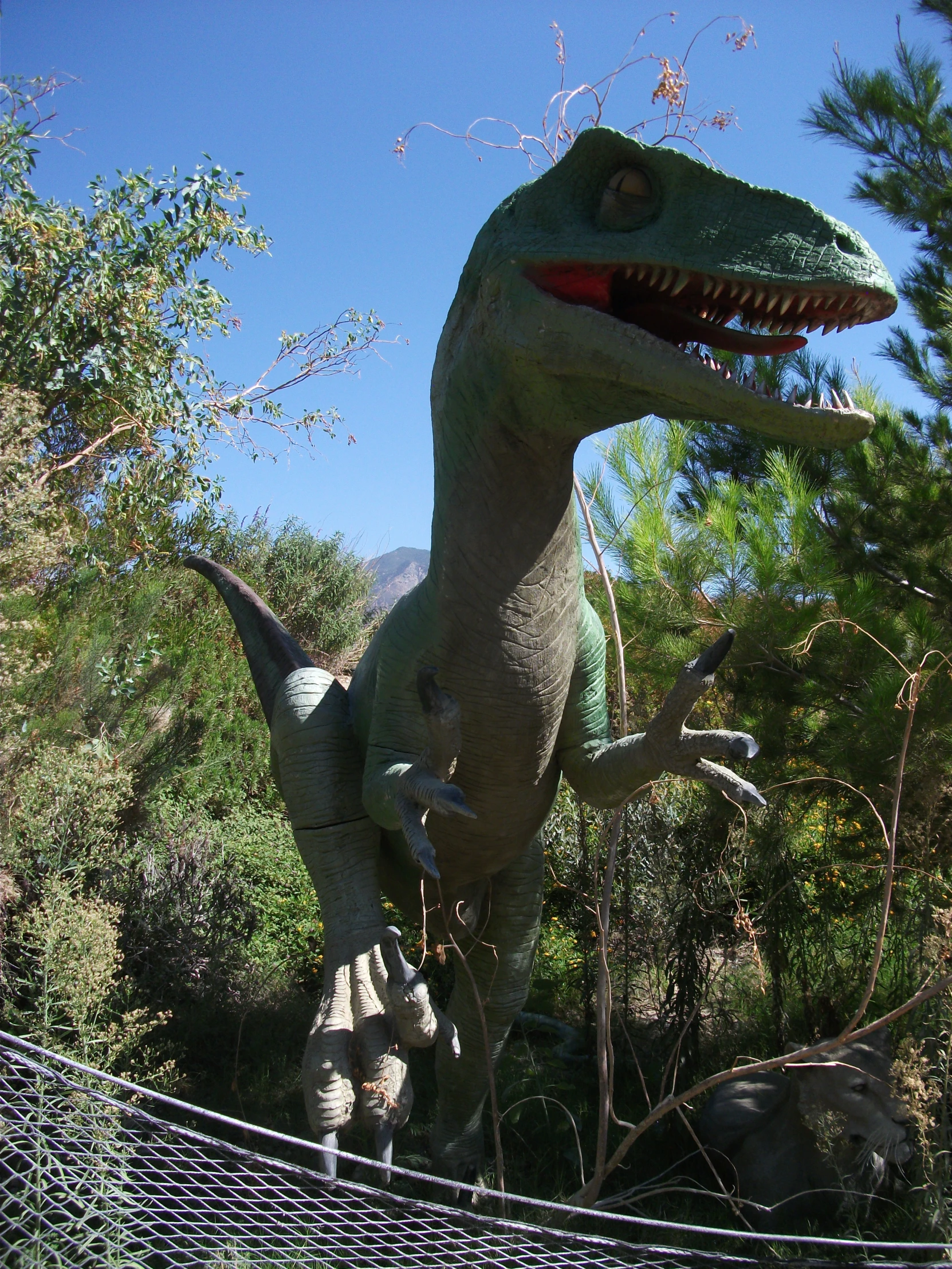 a fake t - rex on top of a large lizard statue