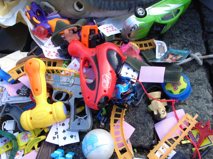 toy vehicles and toys in pile with gray background