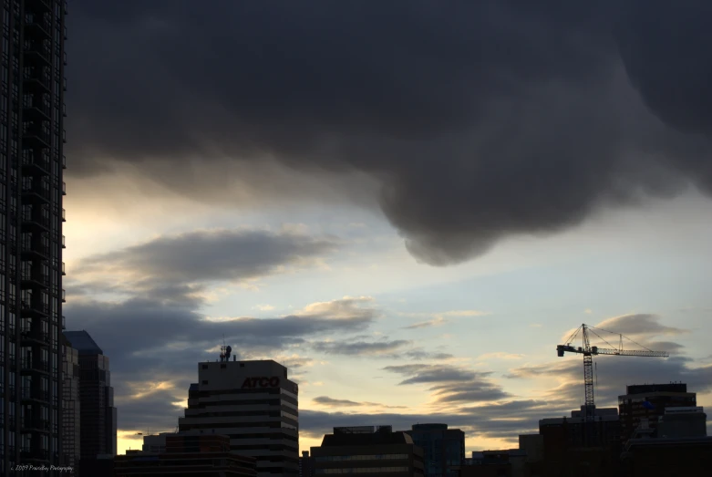 a tower crane and crane against a cloudy sky