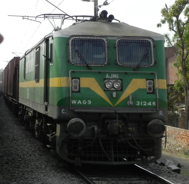 a green train is moving on the track