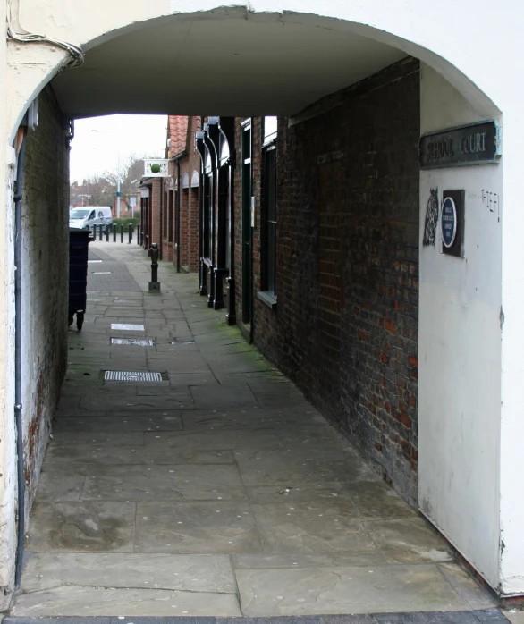 a large arched sidewalk leading into an area where a few buildings are standing