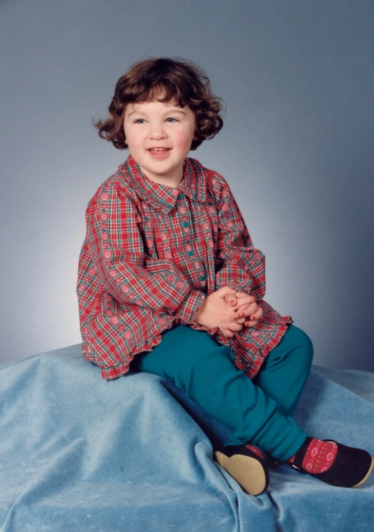 a young child sits on top of a bed