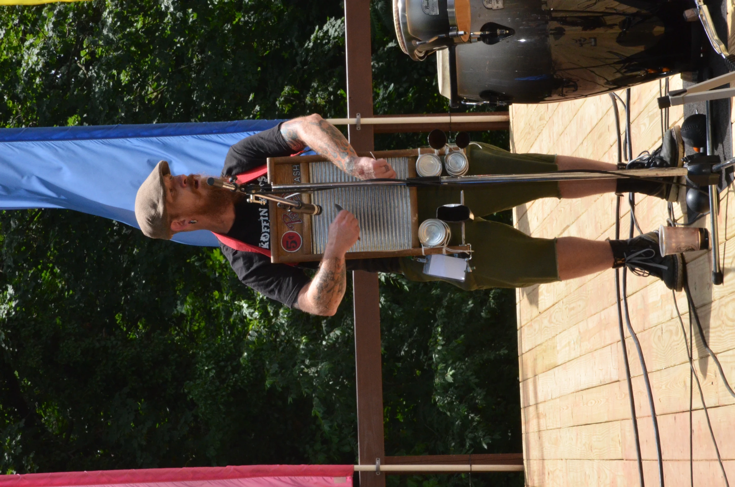 a man wearing overalls and carrying a drum