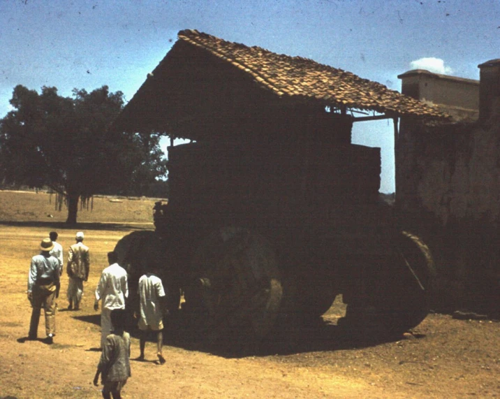 some men walking a group near a wooden structure