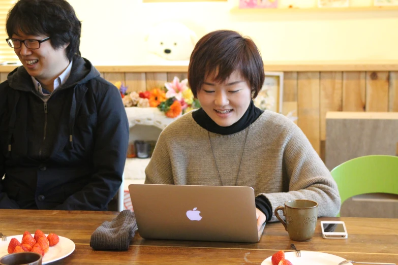 an asian woman and a man working on a laptop