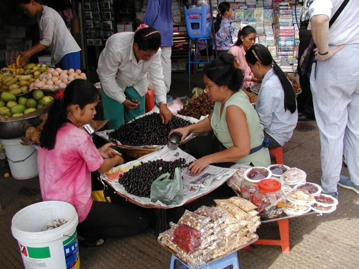 two women and a child at an outdoor market