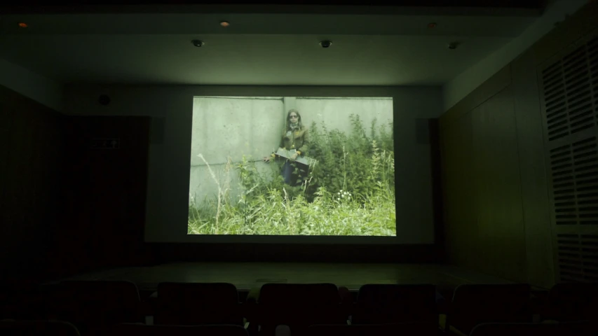 a screen with people sitting on the ground