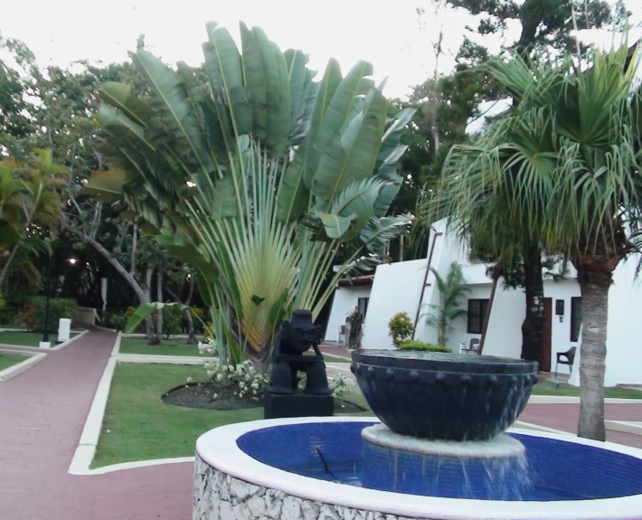 a blue and white fountain in the middle of a large lawn