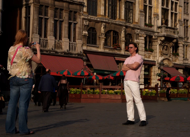 two people are on a street and one is holding a cell phone