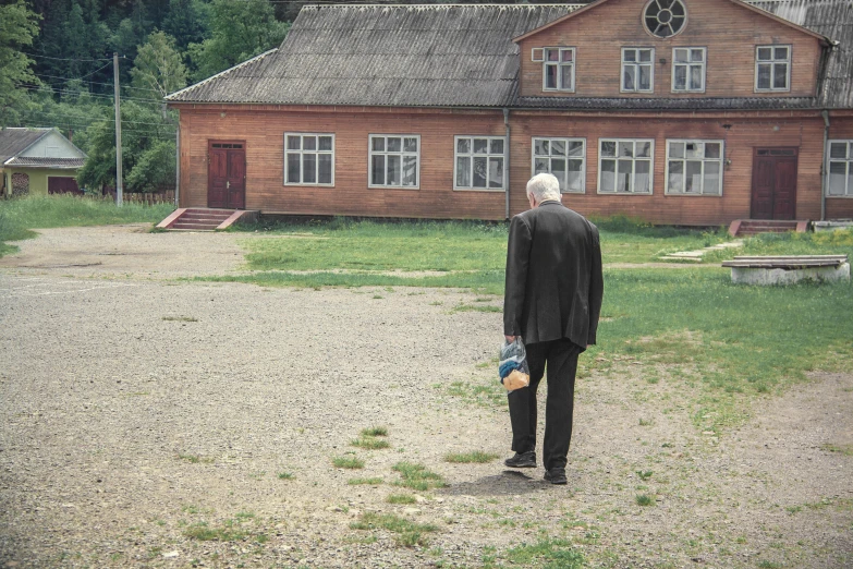 a person in a black coat is looking out at the house