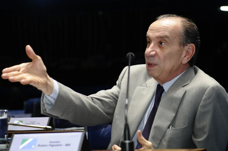 a man speaking to an audience at a meeting