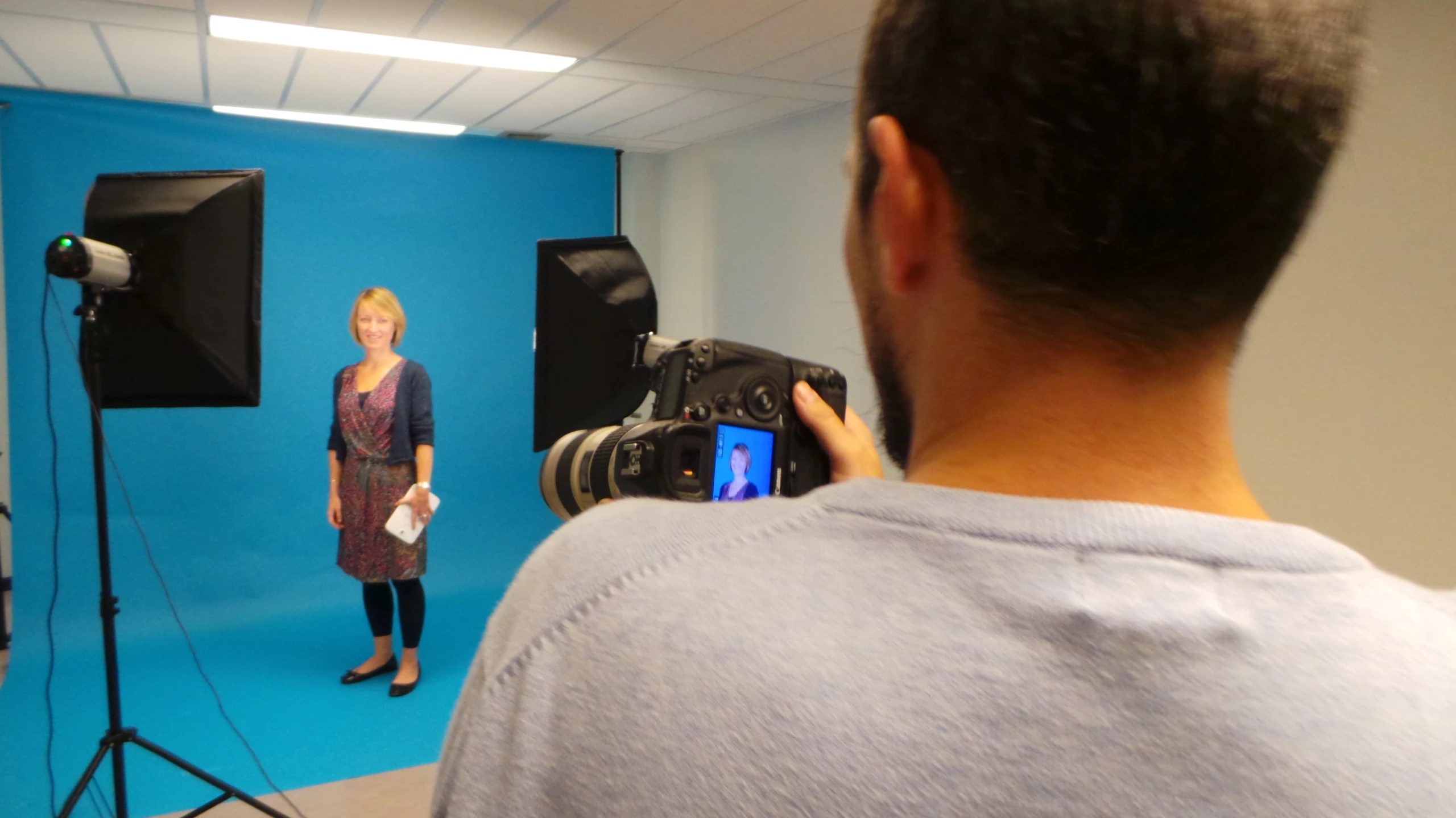 a woman is in front of a blue backdrop