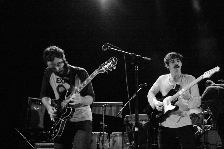 a black and white po of two men playing guitar