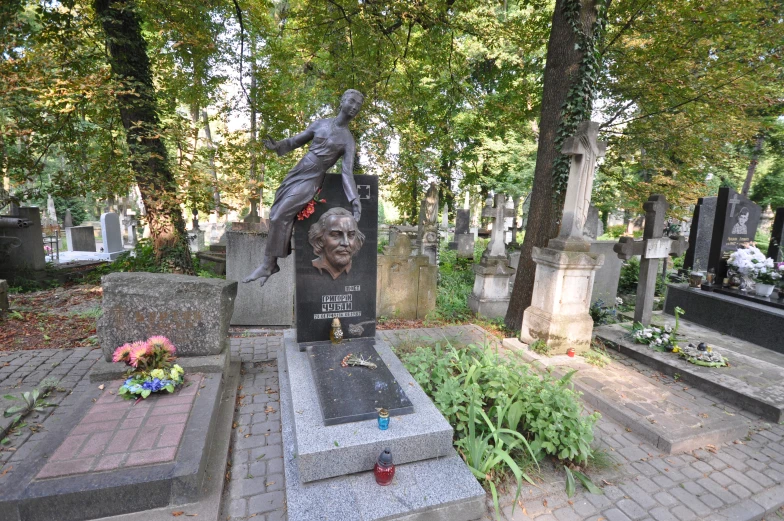 headstones sit on the sidewalk in front of some graves