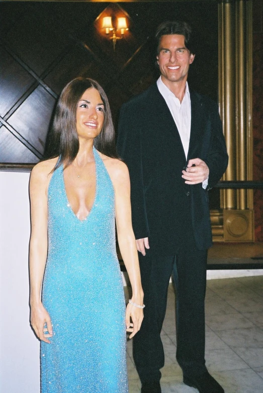 two people stand next to each other in formal dress