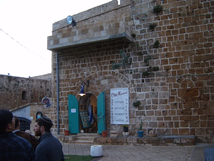 two men sit in front of an old building