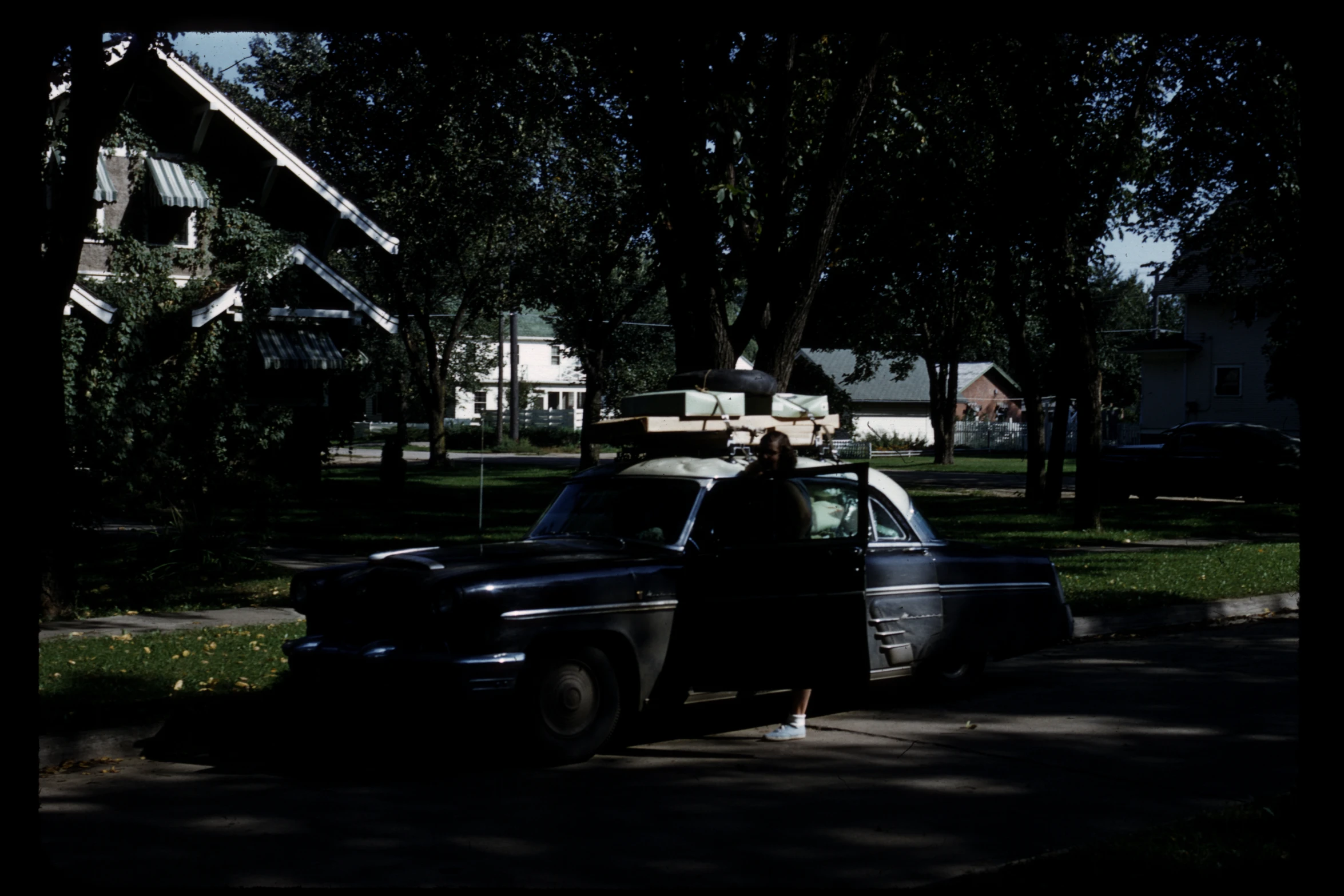 an old truck parked on the street in front of a house