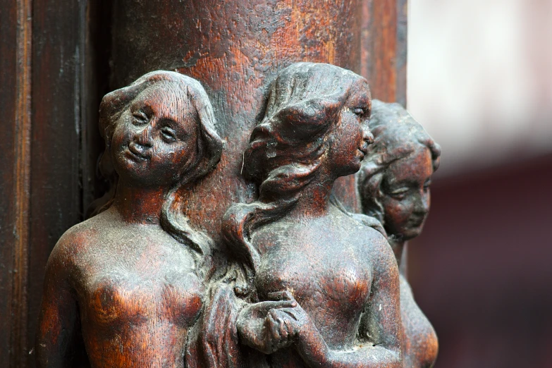 two carved statues of women are shown on a building