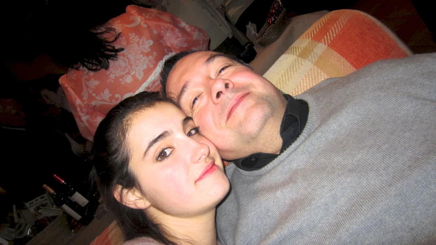 man and woman laying on a bed with their head close to each other