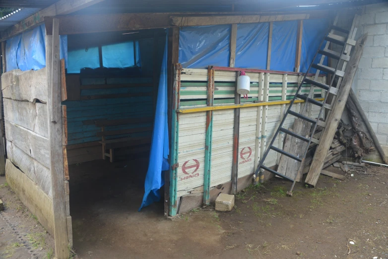 a small shed with siding and wood on it