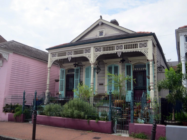 pink houses with green shutters and iron fence