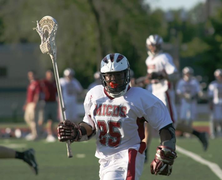 a lacrosse player in uniform holding a stick