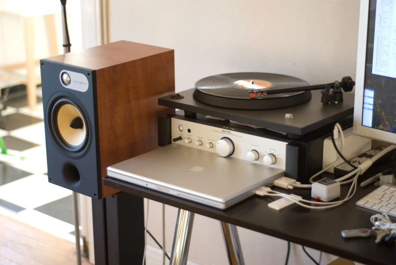 a turntable with a record player on it in front of a computer
