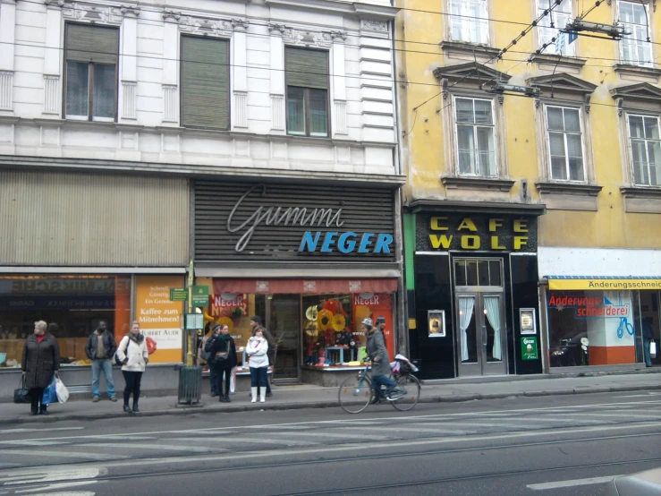 a street scene with people walking and shops