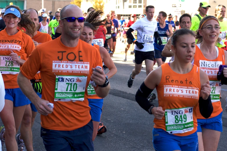 people in orange shirts run a race