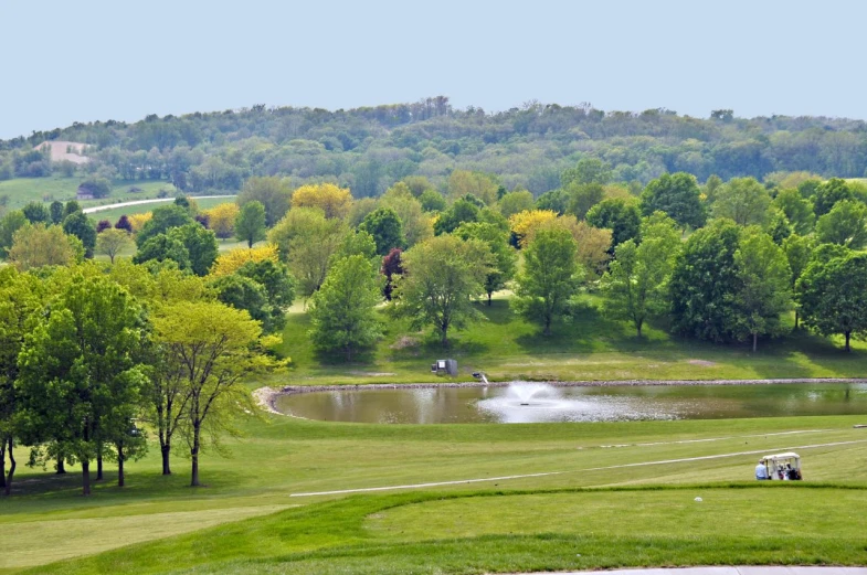 a golf course with several players in it and a lake