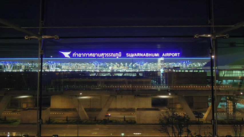 an illuminated airport gate with an airplane at night