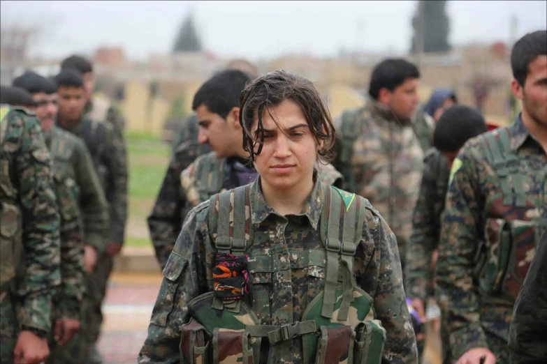 women in camouflage uniforms with one person facing the camera